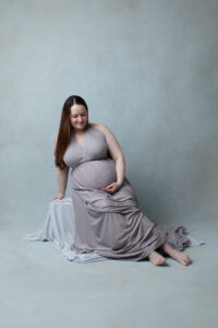 maternity portrait on blue backdrop
