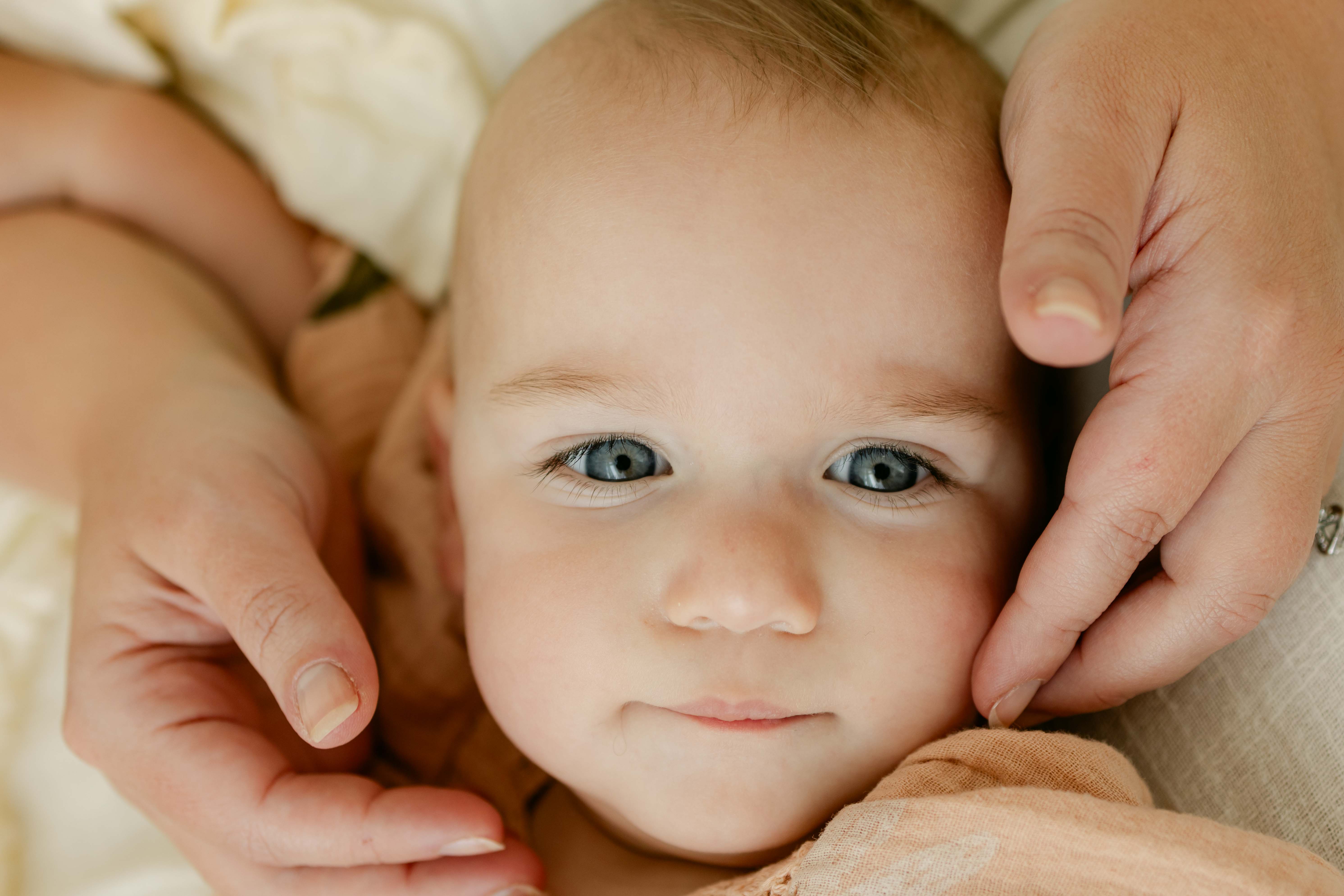 baby with hands on her face