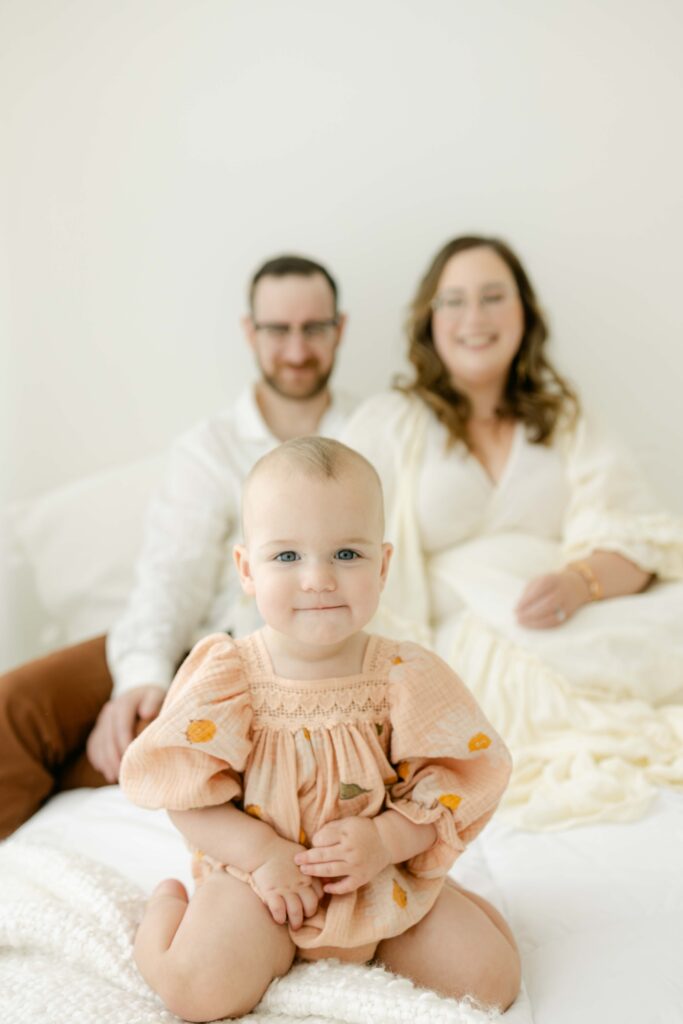 baby smiling in front of her parents