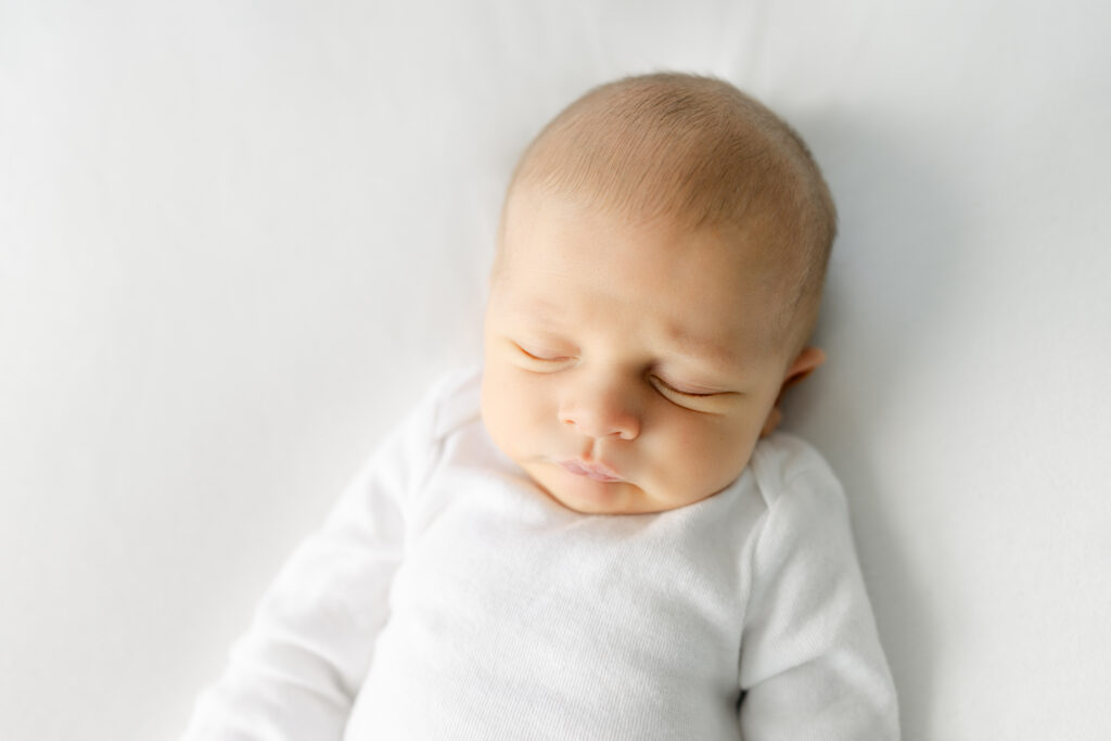 10 day old newborn baby boy in a white onesie