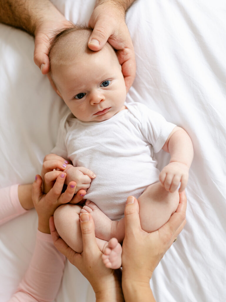 7 week old baby boy with family's hands