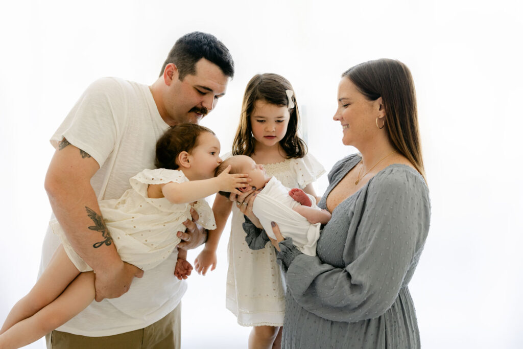 parents and 2 little girls with a mom holding a newborn baby boy